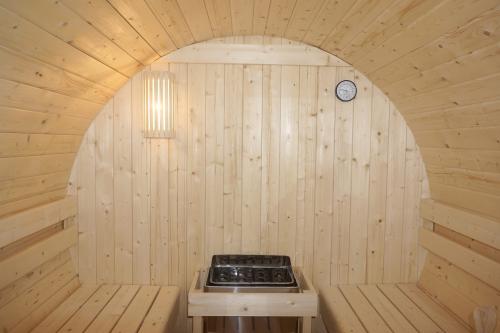 Sauna zewnętrzna ogrodowa 4 osobowa sucha Fińska w kształcie beczki świerk z siedziskami zewnętrznymi BERGEN F70220 Sanotechnik ściana tylna piec